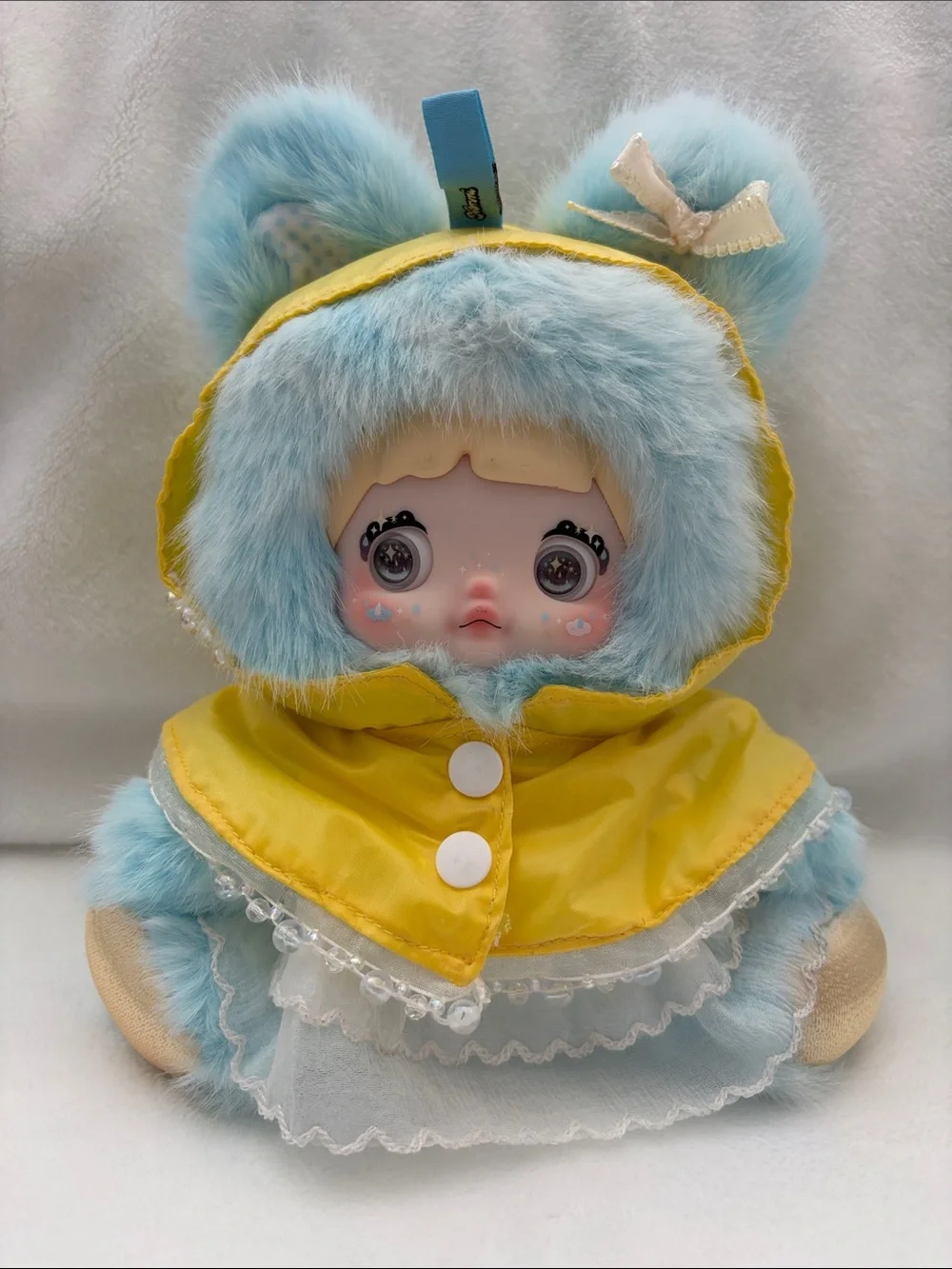 Nommi Drizzle plush doll yellow raincoat blue faux fur figure